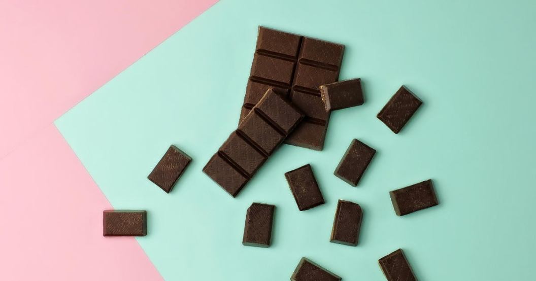 dark-chocolate-bar-pieces-on-a-pink-and-mint-green-color-blocked-background.jpg