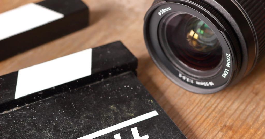 Film Clap Board Film Slate with Camera Lens on Wooden Background