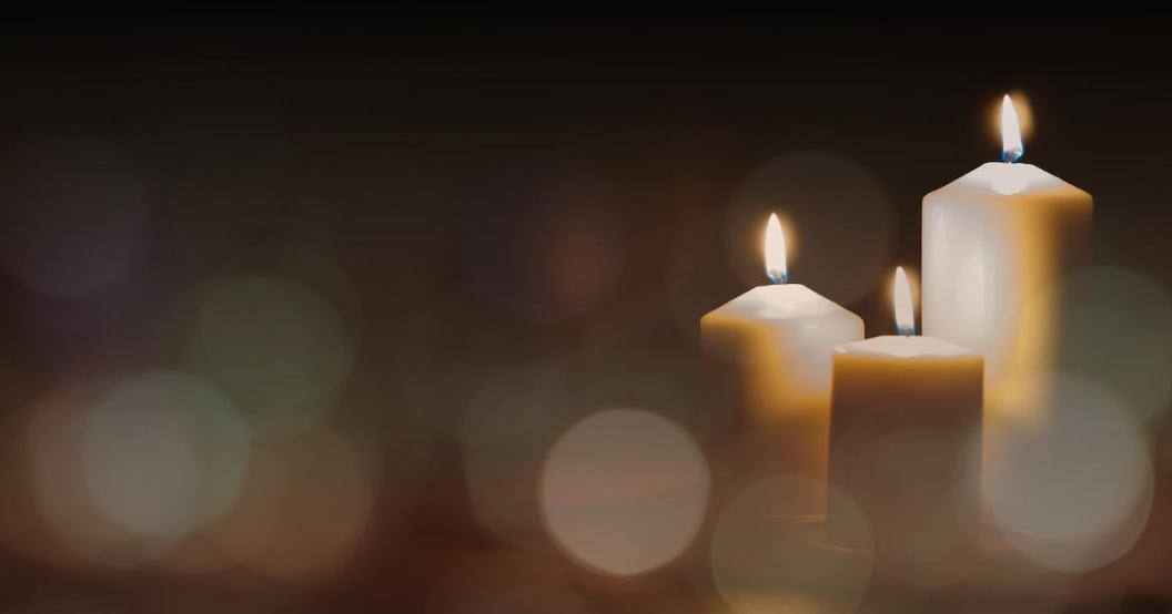 Christmas advent candle light in church with blurry golden bokeh for religious ritual or spiritual zen meditation, peaceful mind and soul, or funeral ceremony