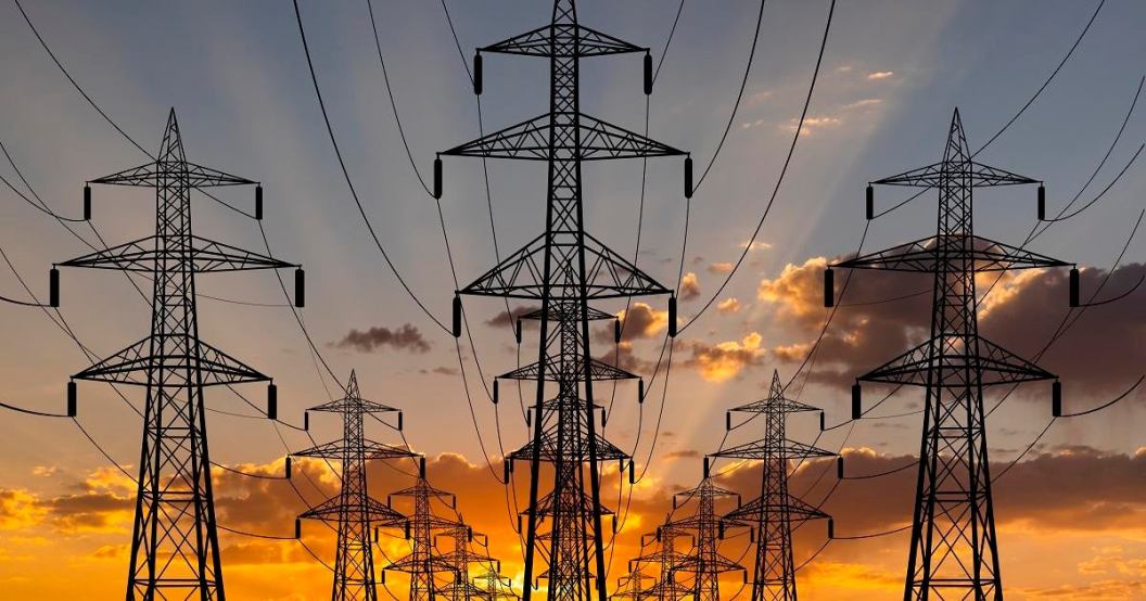 High voltage towers at sunset background. Power lines against the sky