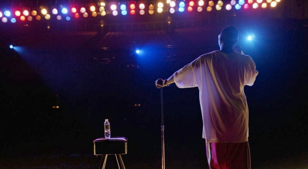 Comedian standing on stage, rear view