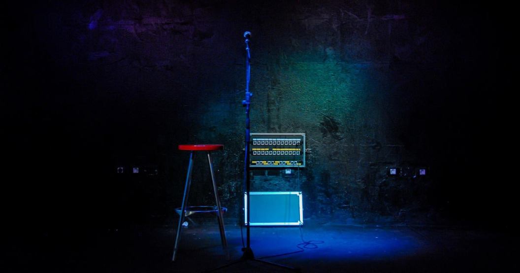 mic-and-stool-in-an-dark-empty-stage-with-an-open-connections-box.jpg