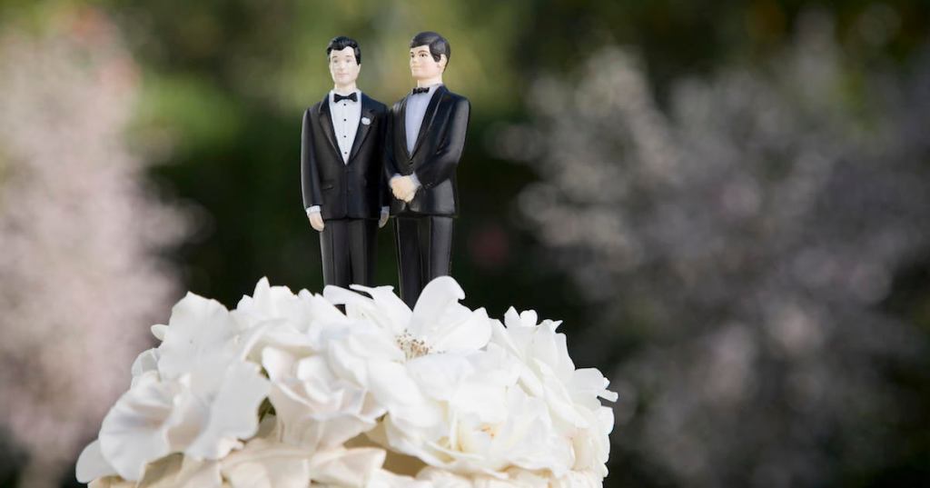 Two male figurines on top of wedding cake, close-up