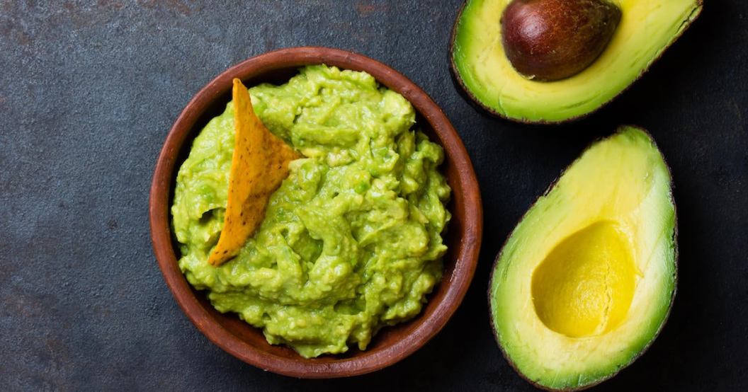 Latin American sauce guacamole and avocado sandwiches on dark background.