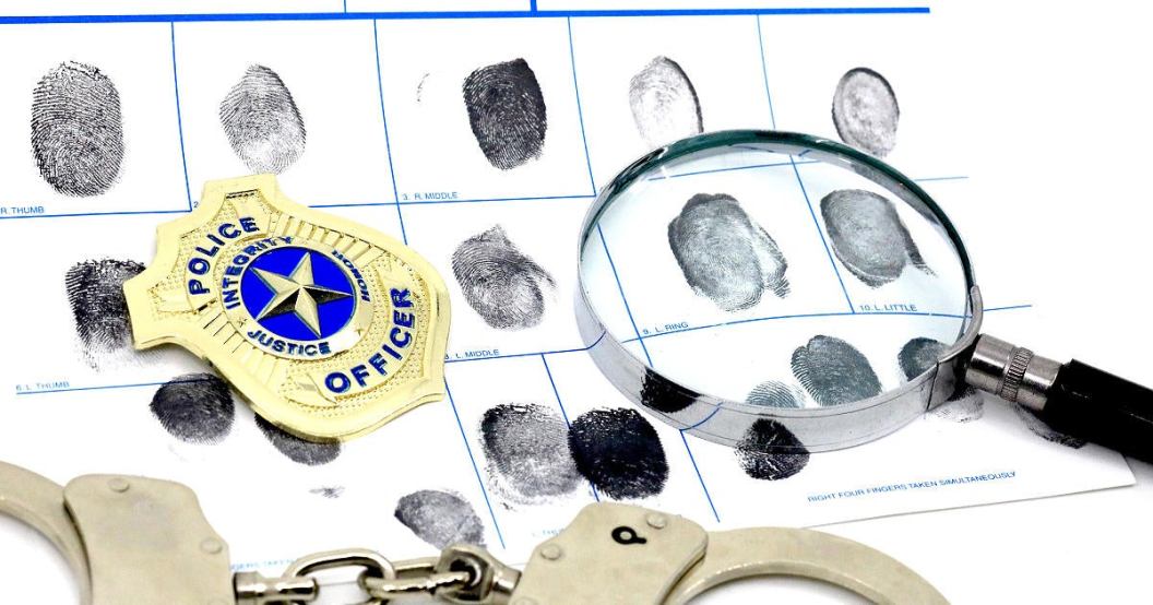 handcuffs-magnifying-glass-fingerprints-police-badge.jpg