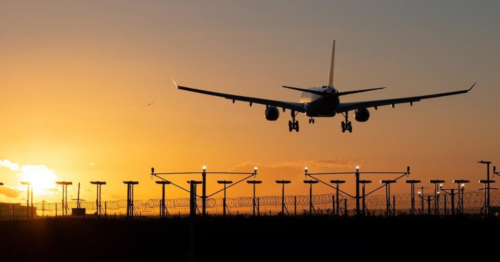 Landing passenger plane during sunset.