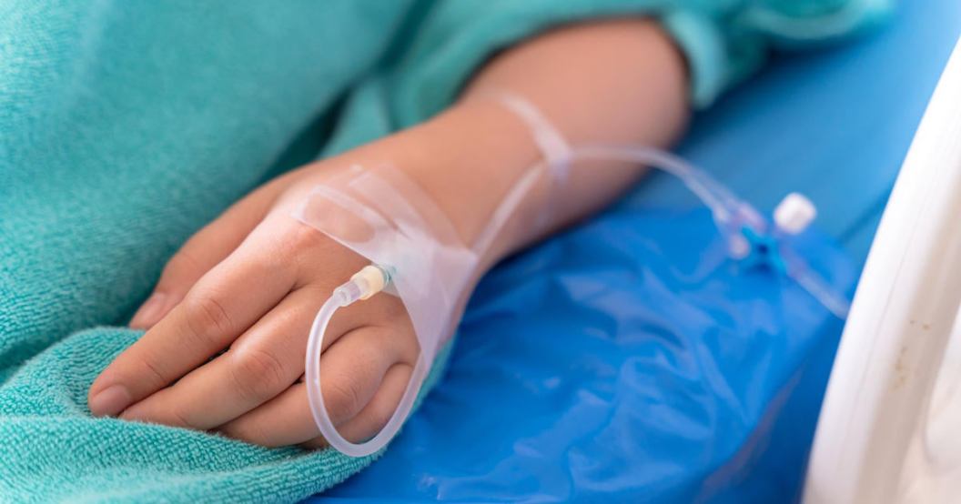hand of the patient is on drip receiving a saline solution on bed VIP room at hospital. Medical Concept.