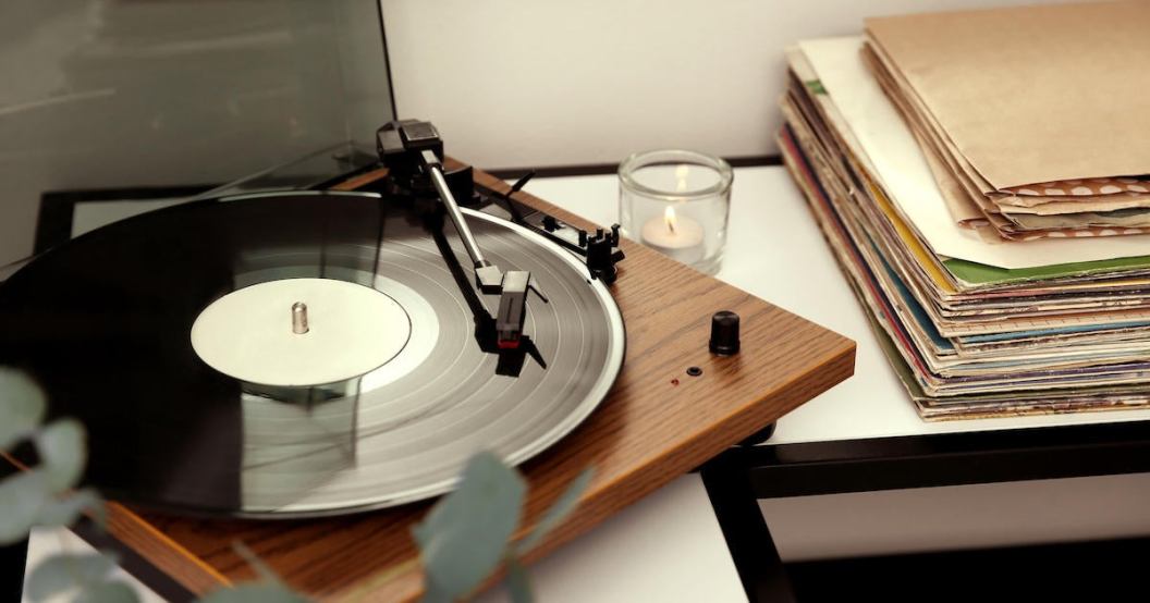 Stylish turntable with vinyl record on table indoors