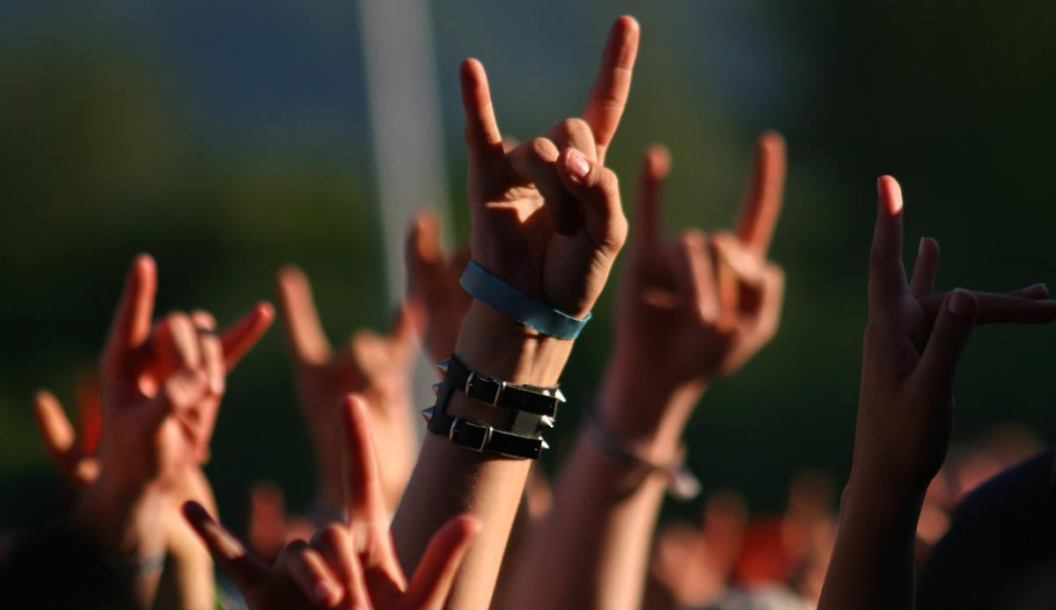 Hands in air at concert making rock sign gesture